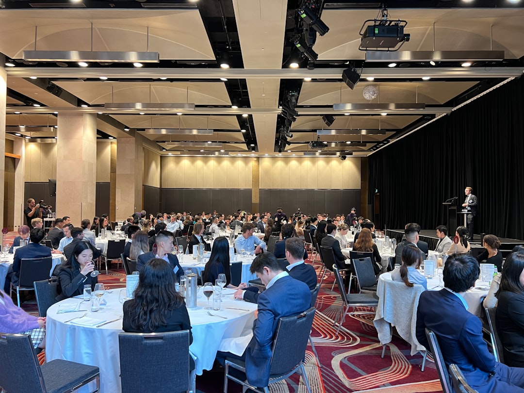 a-group-of-people-sitting-at-tables-5mwo-cgcxaa